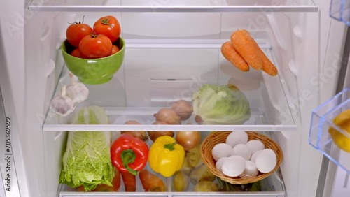 male hands take a basket of organic potatoes from the fridge
