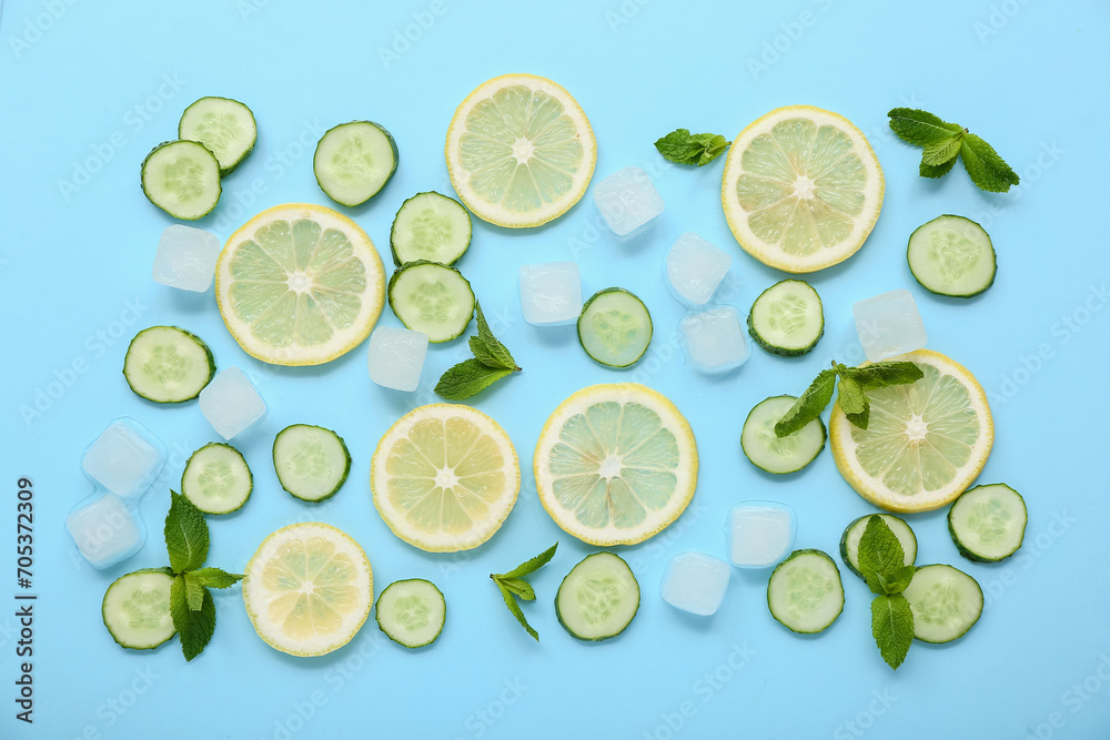 Lemon with cucumber, mint and ice cubes on blue background. Ingredients for mojito