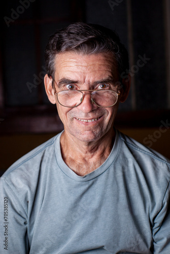 elderly man smiling with glasses and t-shirt