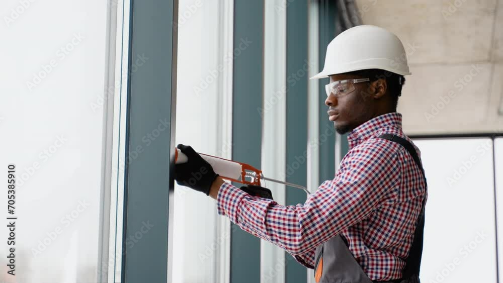 African windows installation worker use of silicone foam when installing pvc windows African windows installation worker use of silicone foam when installing pvc windows