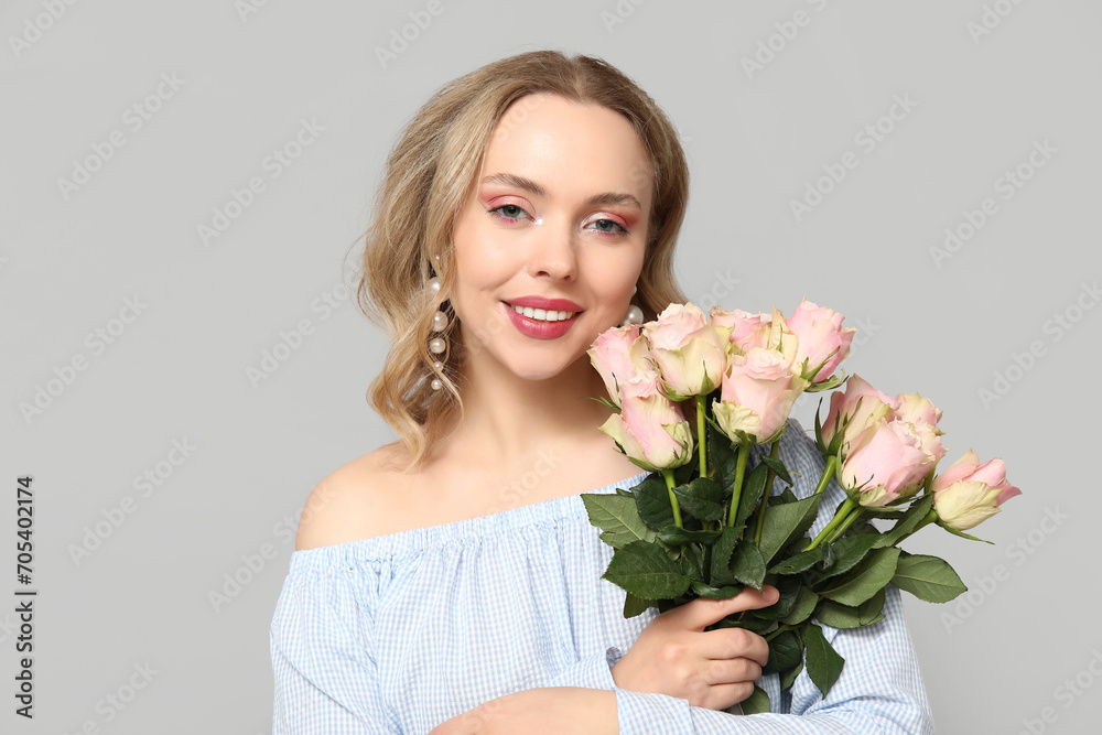 Happy young woman with bouquet of beautiful roses on grey background Happy young woman with bouquet of beautiful roses on grey background