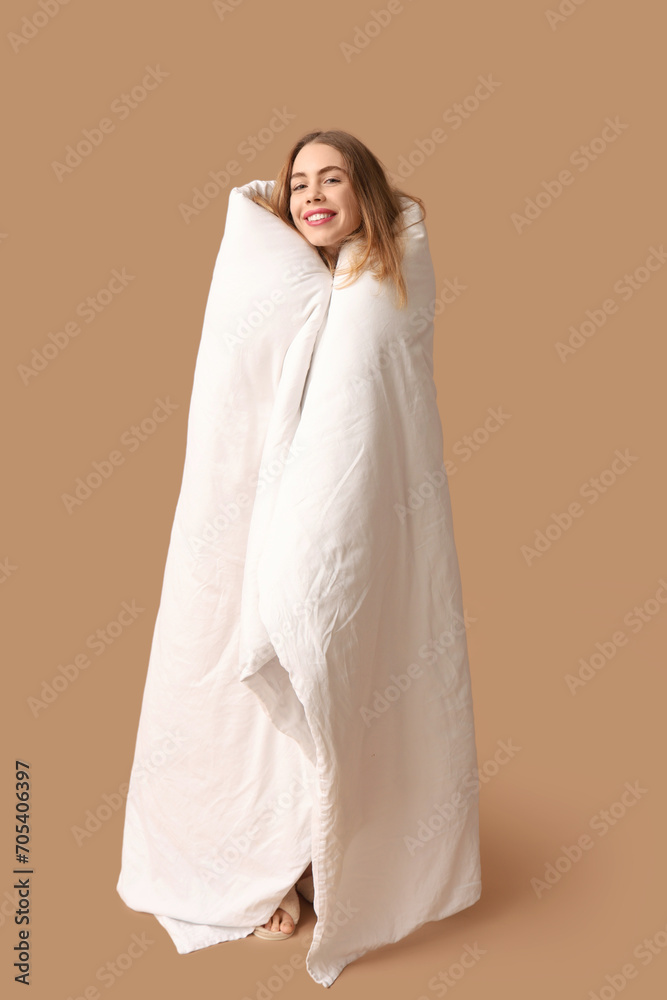 Beautiful young happy woman with soft blanket on brown background Beautiful young happy woman with soft blanket on brown background