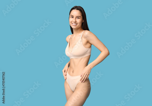 Beautiful young woman in underwear on blue background. Epilation concept