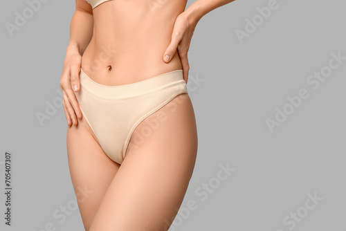 Young woman in underwear on grey background. Epilation concept