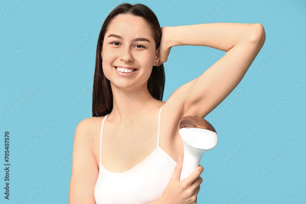 Happy young woman with modern photoepilator on blue background Happy young woman with modern photoepilator on blue background