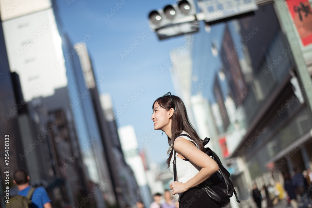 Cool urban style, Confident Japanese lady enjoying leisure and technology in the trendy streets of Tokyo.