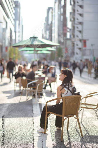 Experience urban joy in Tokyo, a happy asian woman enjoying city bench.