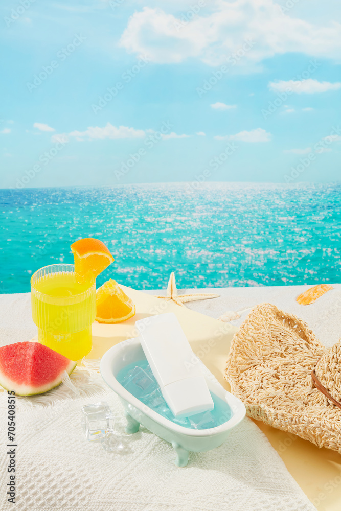 Close-up of an unlabeled tube of sunscreen inside a mini bathtub, a glass of orange juice, watermelon, starfish and a straw hat on a white surface with a blue sea background.