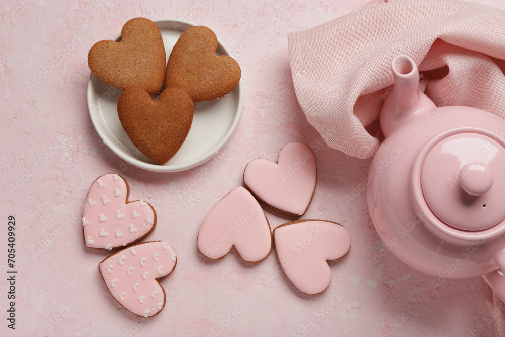 Obraz premium Teapot with tasty heart shaped cookies on pink grunge background. Valentine's Day celebration
