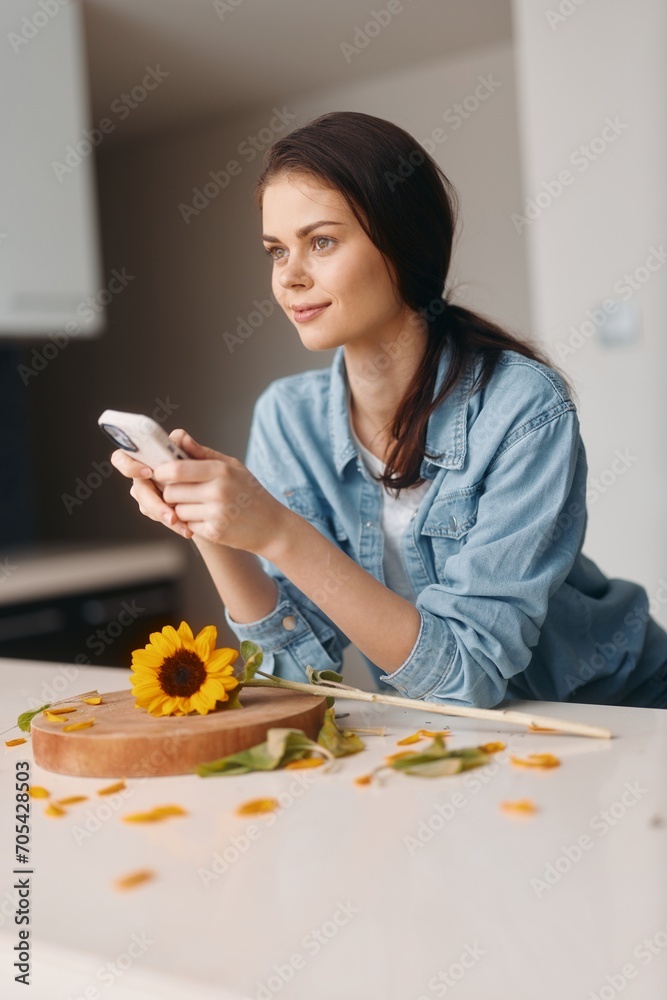 Attractive Caucasian Woman Sitting at Kitchen Table, Using Smartphone and Enjoying Healthy Breakfast in Cozy Home Interior Attractive Caucasian Woman Sitting at Kitchen Table, Using Smartphone and Enjoying Healthy Breakfast in Cozy Home Interior