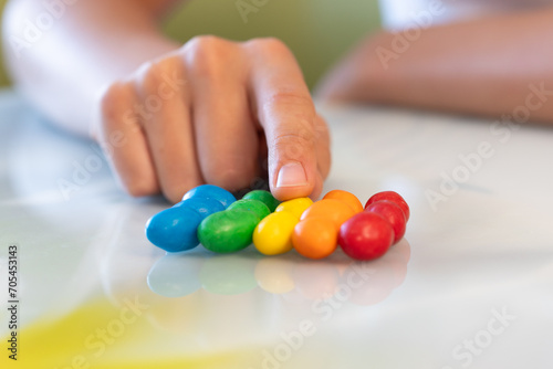 Amazed sweet-tooth. Beautiful child girl holding colorful chocolate drops
