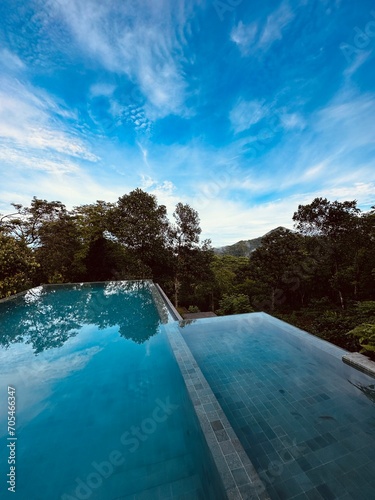 Infinity Swimming pool with mountains scenery on background