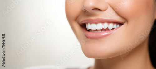 Perfect white teeth smile of young woman with glossy lips, close up. The result of the teeth whitening procedure. Oral care dentistry concept. Tooth whitening, female toothy veneer smile. Stomatology
