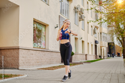 Woman tracking her workout progress while jogging outdoor