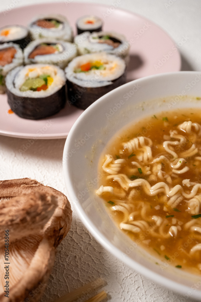 Chop sticks, mushrooms, noodle ramen, California rolls and Philadelphia rolls on a small plate on a pink background
Chop sticks, mushrooms, noodle ramen, California rolls and Philadelphia rolls on a small plate on a pink background