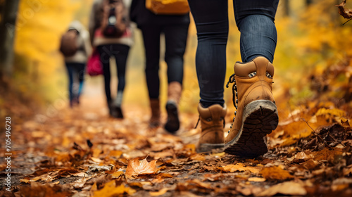 Group of tourists walking along the path of the autumn forest. Feet close-up