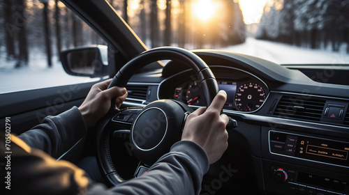 close up of hands on steering wheel in car at sunset in snowy pa photo