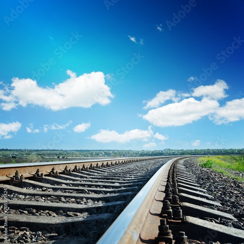 railroad to horizon under blue cloudy sky