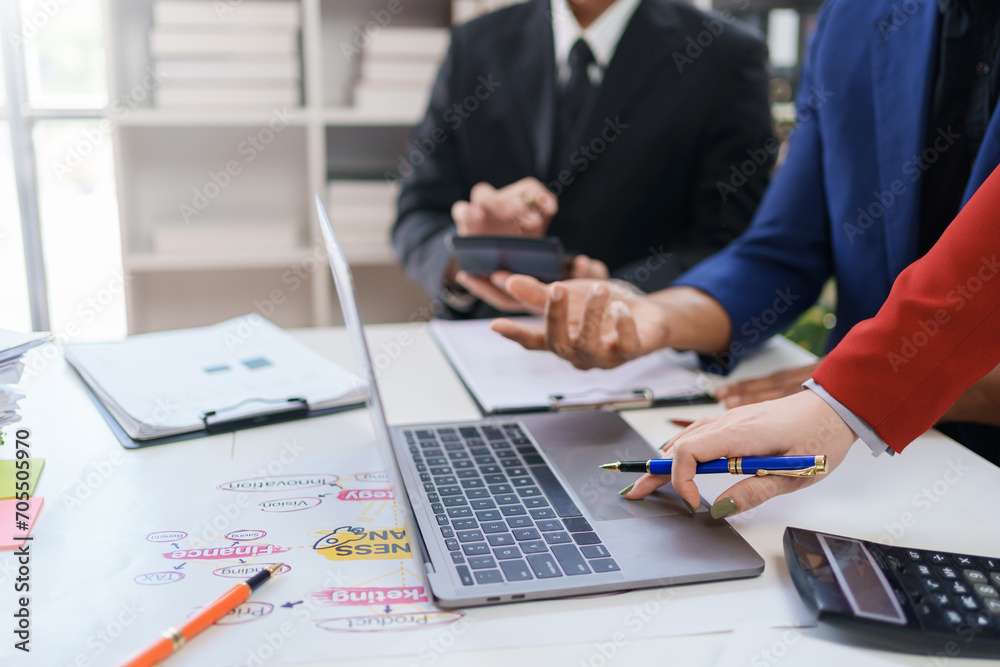 Business representatives meeting pointing on laptop computer. Business team discussing investment plan using data on laptop. Business representatives meeting pointing on laptop computer. Business team discussing investment plan using data on laptop.