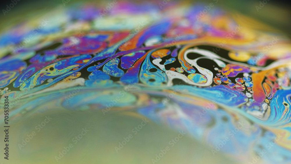Neon paint. Holographic sphere. Psychedelic dream. Defocused rainbow color oil bubble fluid ink mix flow motion on black abstract art background.