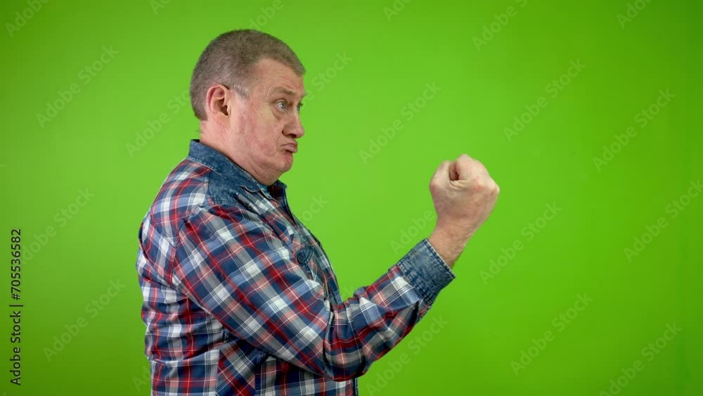 Disgruntled senior caucasian man threateningly showing fist and shakes finger. Disgruntled senior caucasian man threateningly showing fist and shakes finger.
