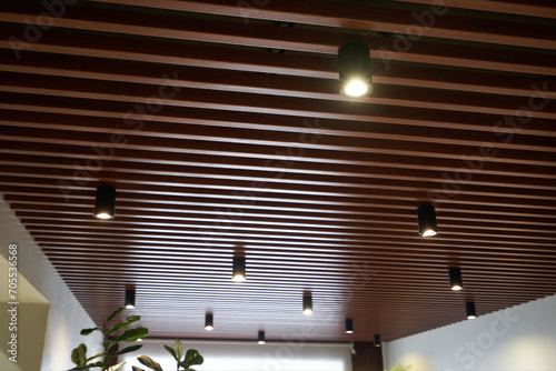 The ceiling is made of wooden slats with spotlights