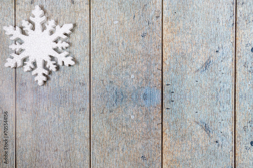 One snowflake on a light blue wooden background. Christmas winter flatlay with copyspace