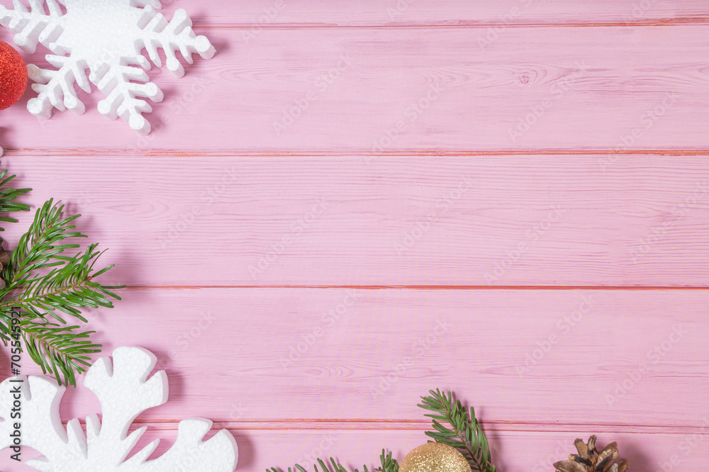 Snowflakes, pinecons, branches, balls on a pink wooden background. Christmas winter flatlay with copyspace	