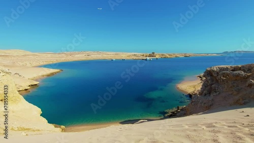 Blue lagoon in the reserve of Ras Mohammed National Park of Egypt. Tourism travel in Sharm El Sheikh, sightseeing attraction. Vacation rest holiday. Sea bay, sandy beach. Plane is flying in background photo