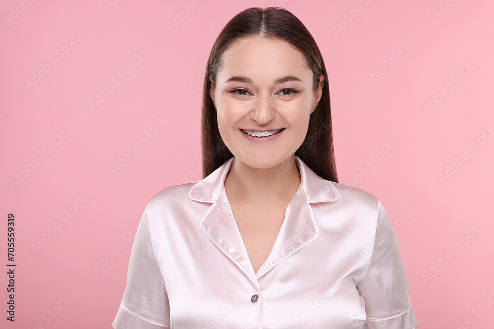 Smiling woman with dental braces on pink background Smiling woman with dental braces on pink background