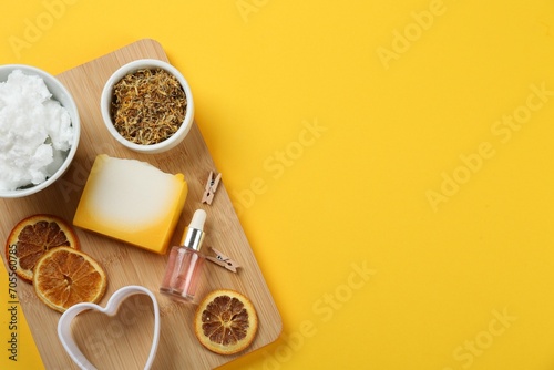 Flat lay composition with natural handmade soap and ingredients on yellow background. Space for text photo