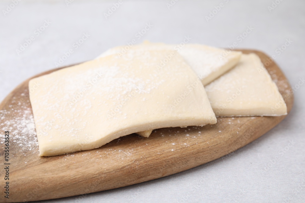 Raw puff pastry dough on white table, closeup Raw puff pastry dough on white table, closeup