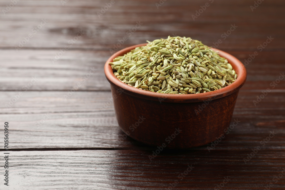 Fennel seeds in bowl on wooden table, closeup. Space for text Fennel seeds in bowl on wooden table, closeup. Space for text