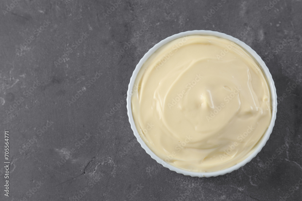 Fresh mayonnaise sauce in bowl on grey table, top view. Space for text Fresh mayonnaise sauce in bowl on grey table, top view. Space for text