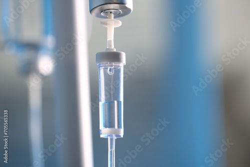 IV drip chamber against blurred light background