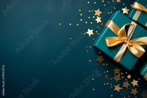Elegant gift box with gold satin ribbon and confetti on dark background. Top view of birthday or Christmas gift with copy space for party. © LunaLu