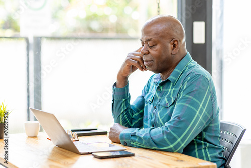 Business senior man 60 years old using laptop computer and thinking about question in office. Happy middle aged man, entrepreneur, small business owner working online.