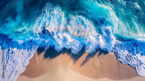 Aerial view of powerful waves on a sunny beach, summer travel.