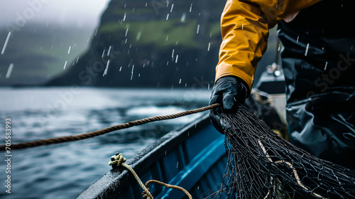 Close up of a Fisherman in rough weather handling nets on his boat. Concept of industrial fishing. Shallow field of view.
 photo
