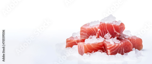 Cubes of tuna meat on a white cutting table with crushed ice. Banner concept for a fish store or seafood department.