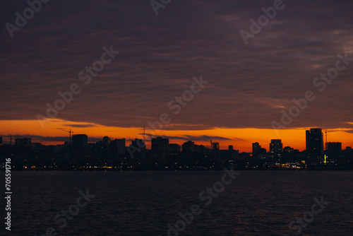 Panoramic view of the city of Dnipro during sunset or sunrise. Amazing sunset at Dnipro river with a view of the historical center. Winter sunset. Evening city. © Denis Chubchenko