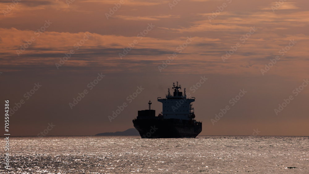 Seascape and silhouette container ship floating in sea Seascape and silhouette container ship floating in sea