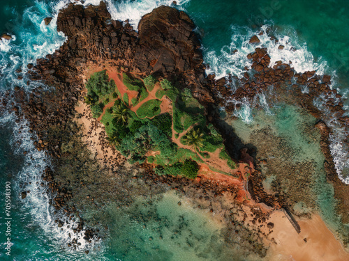 Scenic aerial drone view of Parrot rock - small island along the Mirissa Beach in Sri Lanka. Braking waves top view aerial photo from flying drone. Traveling and exotic countries concept. High quality