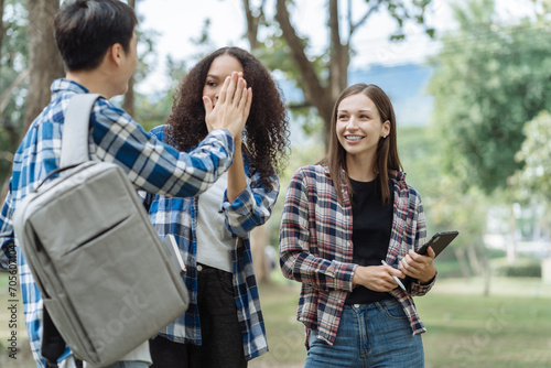 Happy group of college students use laptop feel excited overjoyed with good news over smartphone or Tablet.