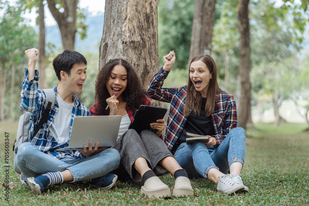 Happy group of college students use laptop feel excited overjoyed with good news over smartphone or Tablet.