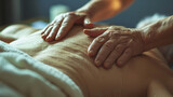 Close-up of therapeutic hands performing a relaxing back massage on old person in a serene spa setting.