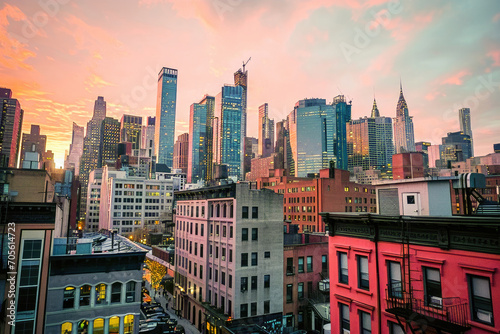 Evening view of a bustling New York cityscape with skyscrapers and a vibrant pink sunset sky. © apratim