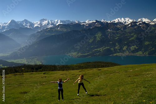 Niederhorn, Emmental Alps, Bernese Oberland, canton Bern, Switzerland, Europe : two young female tourists, panoramic view from the top on Thun Lake and Jungfrau-Aletsch mountains area, UNESCO photo