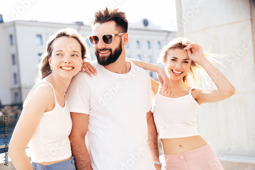 Free Download Group of young three stylish friends posing in the street. Fashion man and two cute female dressed in casual summer clothes. Smiling models having fun. Cheerful women and guy outdoors at sunny day - GFXLoad