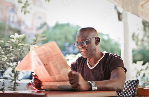 adult man reads a newspaper in a cafe
